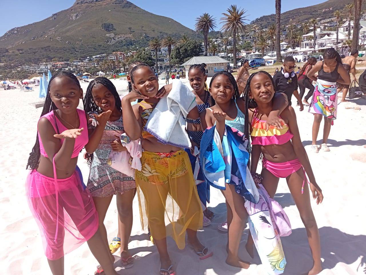 Highridge girls posing on Camps Bay beach during a Cape Town trip
